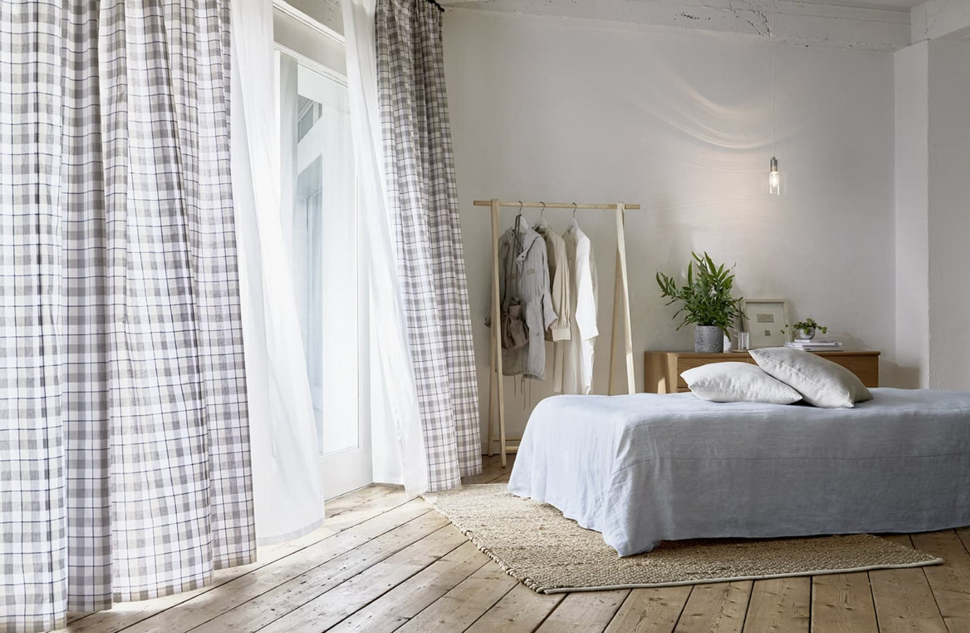 ボーダー柄のカーテンが取り付けされている寝室の写真